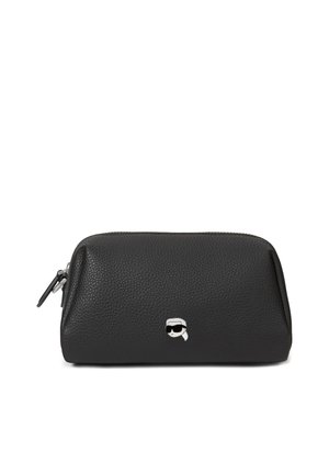 Bolsa de cuero negro texturizado con cremallera y pequeño emblema plateado de una cara con gafas de sol oscuras y una diadema blanca en la parte frontal.