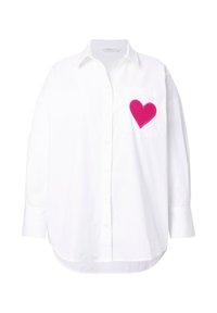 Hvid bluse i bomuld med lange ærmer, der har en lomme og en pink hjerteformet brodering på venstre side. Glat tekstur, afslappet pasform.