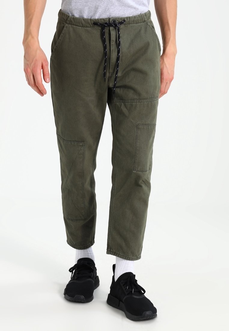 Pantalones cargo verde oliva de algodón con cintura elástica, cordón ajustable y varios bolsillos parche en los muslos.