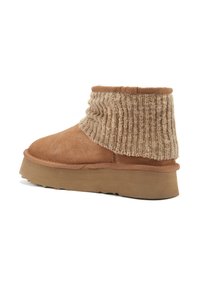 Botas de tobillo de ante color caqui con parte superior de punto plegada. Presentan una suela gruesa y un acento de punto ribeteado texturizado.