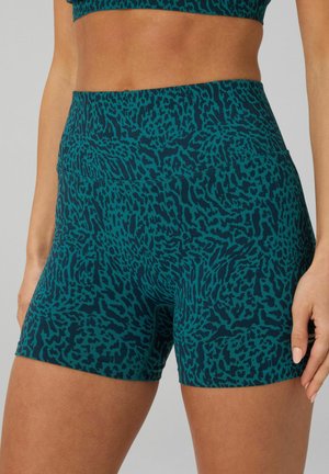 Türkis-schwarz gemusterte, hoch taillenhohe, nahtlose Sportshorts mit Leopardenmuster, getragen von einer Person, die von der Taille bis zur Mitte des Oberschenkels gezeigt wird.