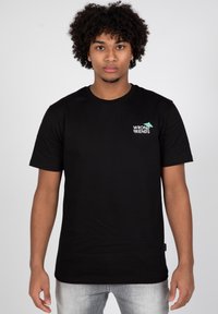 Camiseta de algodón negra con mangas cortas, cuello redondo, que presenta un pequeño logo en verde y blanco que dice "WRONG FRIENDS" en la parte izquierda del pecho.