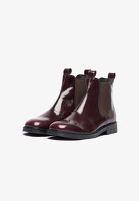 Bottines Chelsea en cuir verni bordeaux avec des panneaux élastiques sur les côtés, bout rond et languettes de tirage ; semelles en caoutchouc noir plat.