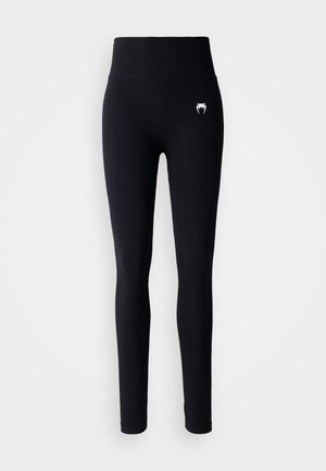 Svarte leggings med høy livhøyde, laget av elastisk stoff. Har en liten hvit logo på venstre lår og tettsittende ben.