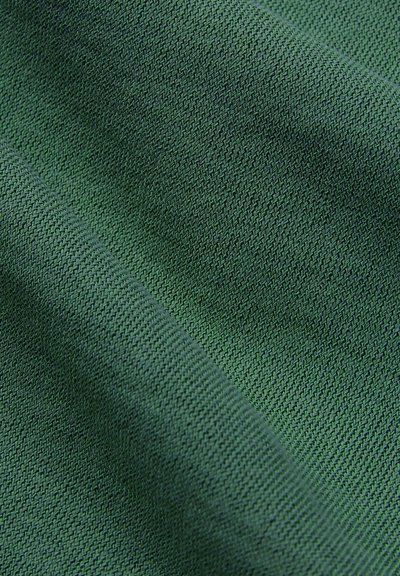 Tessuto di stoffa verde con una trama liscia e morbida e un motivo a maglia stretta. La superficie mostra sottili variazioni di colore e profondità.