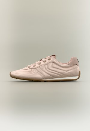 Light pink suede sneaker with wave-pattern stitching, lace-up front, and gum sole against a neutral background.