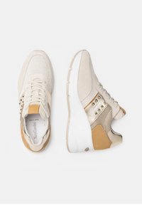 Sneaker in rete e suede beige con dettagli dorati, lacci crema e suola bianca imbottita; presenta borchie decorative sul lato.