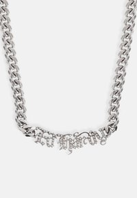 Colar de corrente prateada com um grande centro decorativo em camadas, embelezado com strass, desenhado em estilo cursivo.
