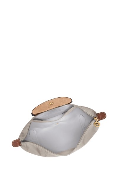 Beigefarbene Stofftasche mit glatter Textur, abgerundeter Form, Lederakzenten und magnetischem Druckknopfverschluss. Innen mit einem hellen Futter ausgestattet.