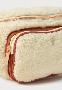 Faux-Shearling-Crossbody-Tasche mit beiger Außenseite und braunen Wildlederakzenten. Verfügt über einen goldenen Reißverschluss und zwei mit Reißverschluss versehenen Fächern zur Aufbewahrung.