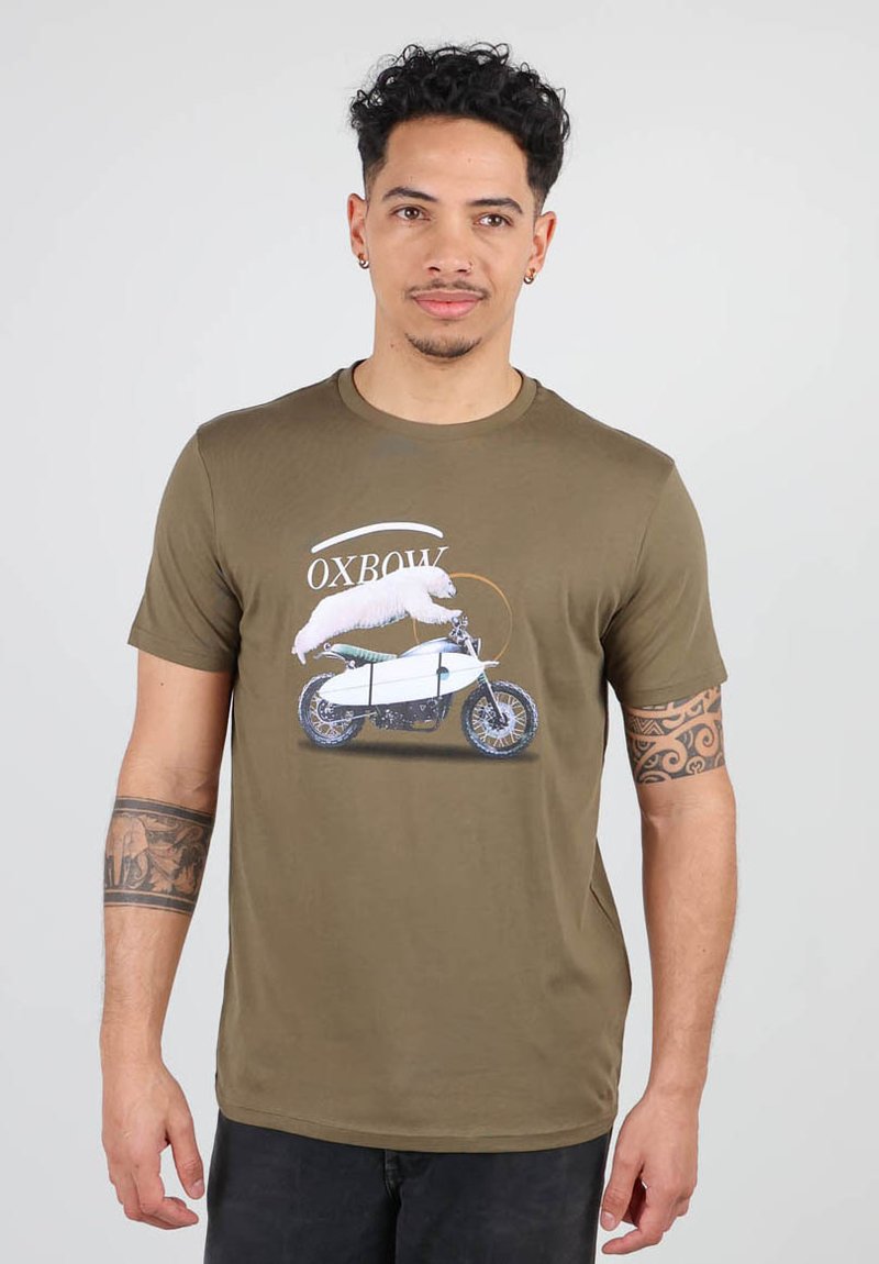 T-shirt vert olive avec un design graphique d'une moto et un ours blanc dessus, avec le texte "OXBOW" au-dessus. En coton.