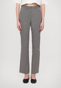 Pantalons évasés noir et blanc à motifs avec une taille élastique, texture de tissu lisse et silhouette ajustée.