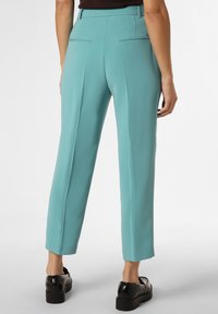 Ljusblå, skräddarsydda byxor med rak skärning, som har bakfickor och en slät yta. Bärs med svarta platåskor.