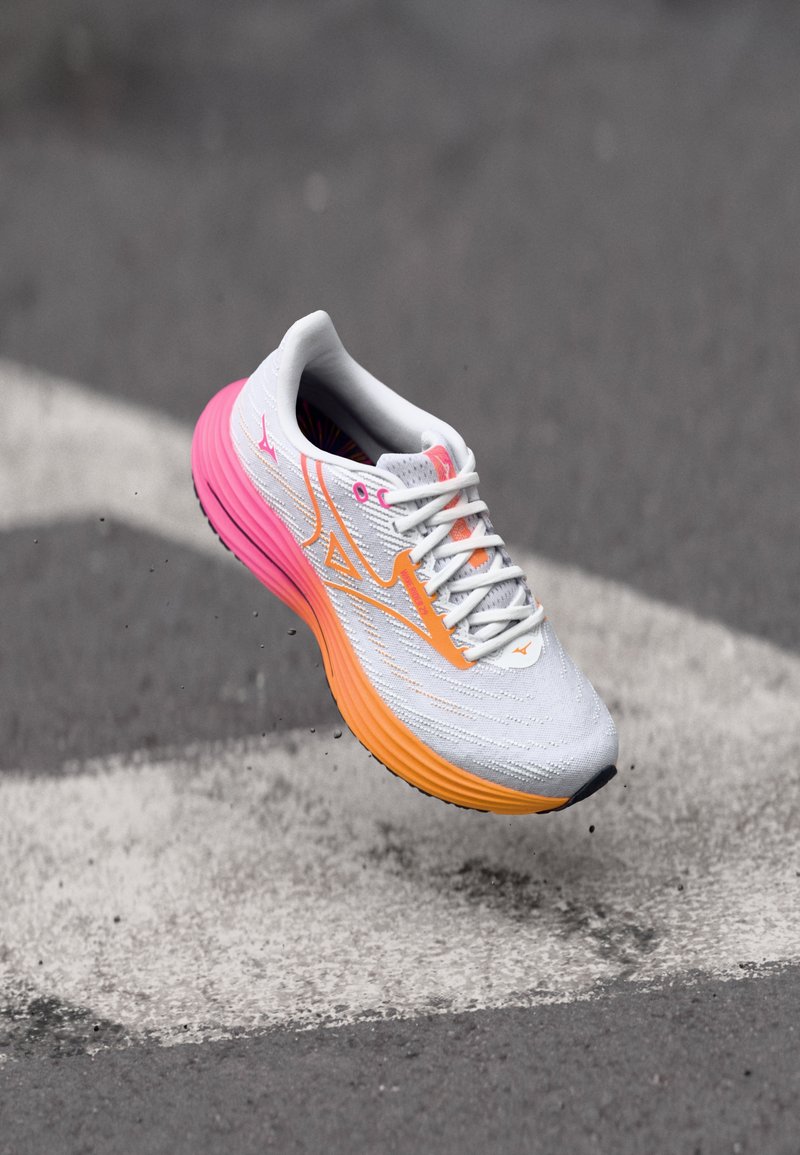Let running sko i grå med pink og orange accenter; har en åndbar overdel, farverigt indre for og tekstureret sål.