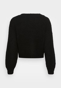 Černý krátký svetr s texturovaným pleteným vzorem, širokými rukávy a žebrovaným výstřihem a lemem. Tkanina působí měkce a bytelně.