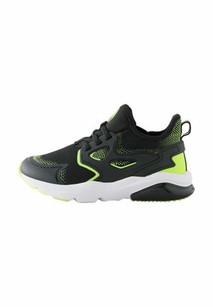 Black athletic shoe with mesh fabric, neon green accents, thick white sole, textured upper, and lacing system for secure fit.