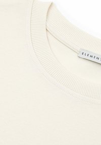 Kremowy sweatshirt z ribbowanym dekoltem i miękką teksturą. Posiada etykietę z napisem "ELEMENT". Brak widocznych wzorów czy akcentów.