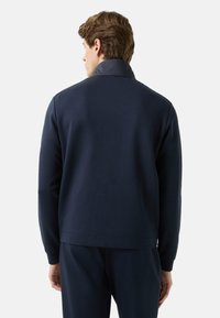 Navy blue sweatshirt with a smooth texture, standing collar, ribbed cuffs, and hem, designed for a modern fit.