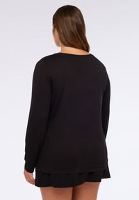 Schwarzes Langarmshirt aus weichem Stoff, mit einem runden Halsausschnitt und einem leicht lockeren Schnitt, gerader Saumlinie und ohne auffällige Akzente.