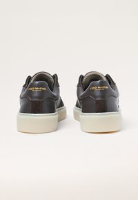 Brown leather sneakers with a textured finish and suede accents. Features a white sole and gold "FRED MARTIN" branding on the back.