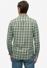 Zielona koszula w kratę z długim rękawem i kołnierzykiem zapinanym na guziki; posiada wzór z ciemnozielonych, jasnzielelnych i białych kwadratów; miękka tekstura tkaniny.