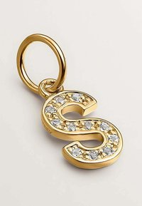Charm dorado en forma de letra "S" adornado con piedras de strass transparentes, con un lazo metálico circular para su sujeción. Textura suave y acabado brillante.