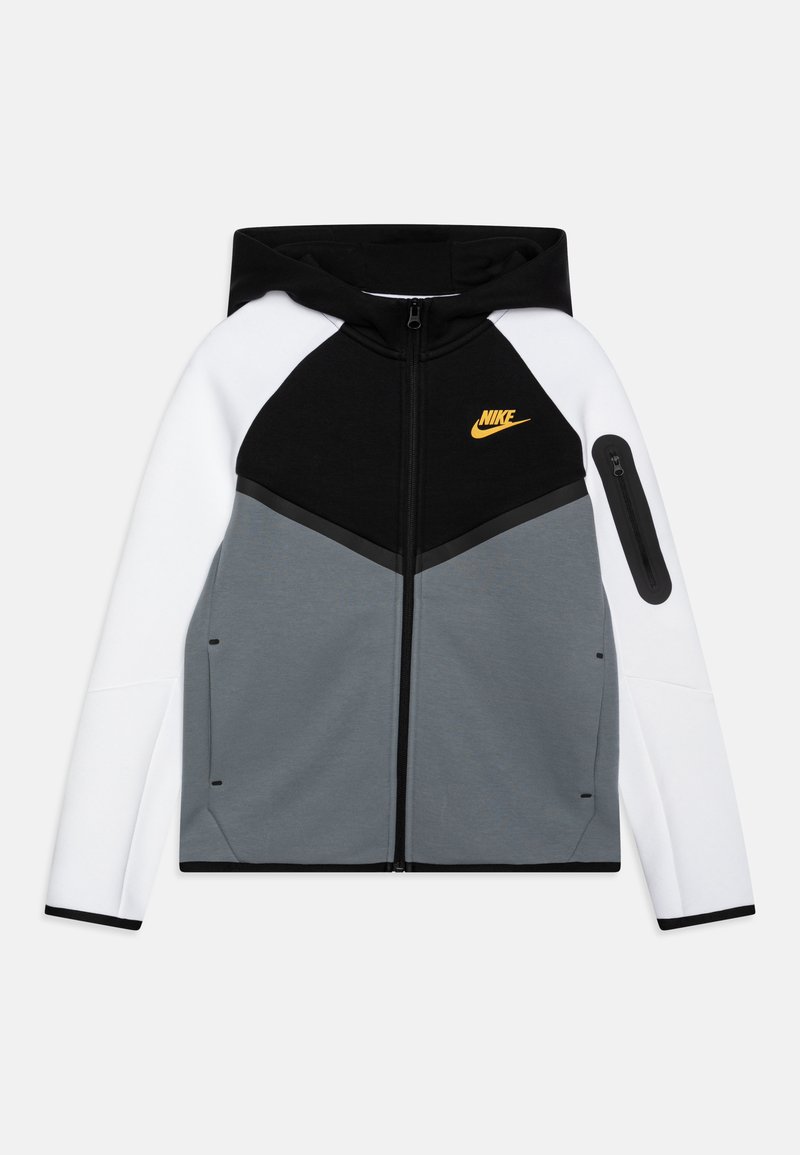 Casaco com capuz e fecho éclair nas cores preto, branco e cinza; possui o logótipo da Nike em laranja, painéis contrastantes e um bolso lateral com fecho.