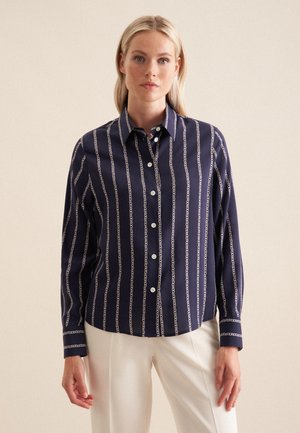 Navy-blaues Hemd mit Knöpfen, vertikalem Kettenmuster, langen Ärmeln und Kragen. Hergestellt aus glattem Stoff mit einem leichten Glanz.