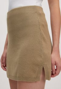 Khaki gebreide minirok met een aansluitende taille, voorzien van zijslitsen, geribbelde zoom en een gladde textuur voor een casual uitstraling.