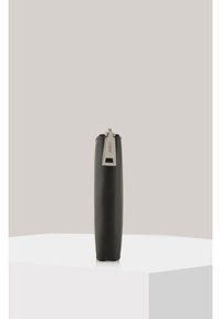 Black leather cylindrical pouch with a smooth texture, featuring a metal zipper pull tab and a polished silver accent.