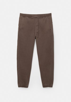 Braune Jogginghosen aus weichem Stoff, mit einem elastischen Taillenbund und einer Kordel, zwei Seitentaschen und tapered Beinen.