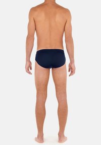 Marineblaue Schwimmbriefs mit enganliegender Passform aus glattem, dehnbarem Stoff. Verfügt über einen Bund, ein minimalistisches Design und keine sichtbaren Muster.