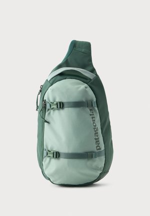 Zaino a tracolla verde Patagonia con due cinghie regolabili e una tasca frontale con cerniera su sfondo semplice.