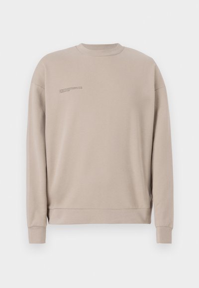 Beige crewneck sweatshirt made of cotton, featuring ribbed cuffs and hem, with a small printed text detail on the left chest area.