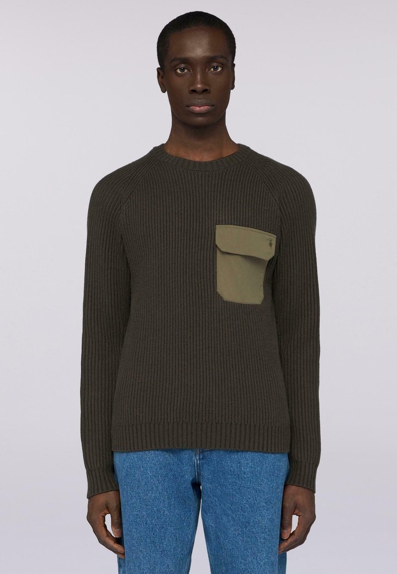 Tmavě zelený žebrovaný svetr s kulatým výstřihem a dlouhými rukávy, s přeloženou kapsou v světlejší zelené na levé části hrudi.