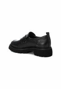 Zapato de cuero negro sin cordones con suela de goma gruesa, adornado con tachuelas decorativas, punta redondeada y un acabado suave.