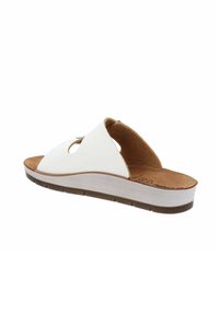Sandalo bianco con design superiore curvo, soletta in sughero e suola texturizzata marrone. Accenti ritagliati notevoli sulla parte superiore.