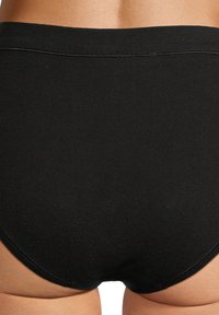 Zwarte hoogversneden onderbroek met een gladde textuur en platte elastische tailleband, met een naadloos ontwerp en geen zichtbare hardware.