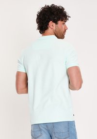 Mintgrøn polo T-shirt med korte ærmer, blød tekstur og et rent design. Har en krave og et lille brandlogo på kanten.