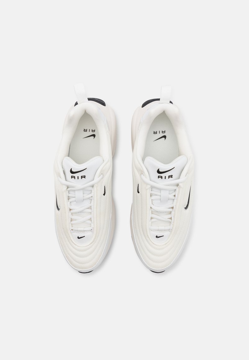Białe sneakersy z teksturowaną siateczką u góry, czarnymi akcentami i sznurowanym zapięciem. Posiadają logo 'AIR' na języku oraz gładką gumową podeszwę.