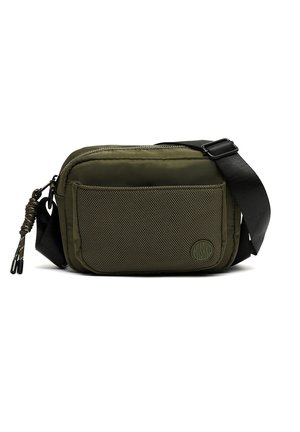 Groene crossbodytas met een gaasvak aan de voorkant, verstelbare zwarte band, ritssluiting en een kleine ronde logopatch op het voorvak.