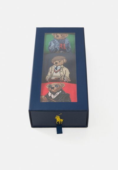 Zils kaste ar ilustrāciju, kurā attēloti četri lāči dažādās drēbēs. Augšējie lāči zaļos un sarkanos foniem, ar detalizētu izšuvumu. Zelta logo akcents.