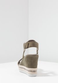 Olivgrön mocka kilklackssandal med justerbart vristband och espadrillastil yttersula med ett texturerat tygband.