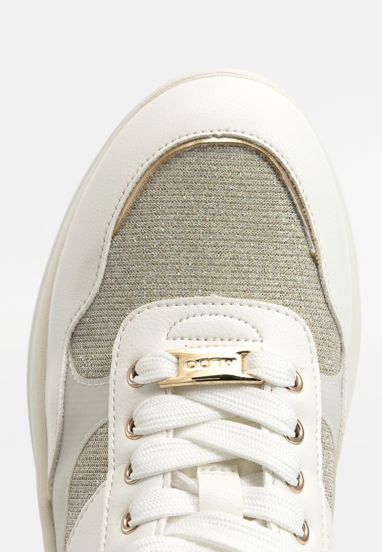 Sneaker bianco con pannello in tessuto grigio chiaro testurizzato, dettagli dorati e lacci rotondi. Punta e dettagli laterali in pelle liscia.