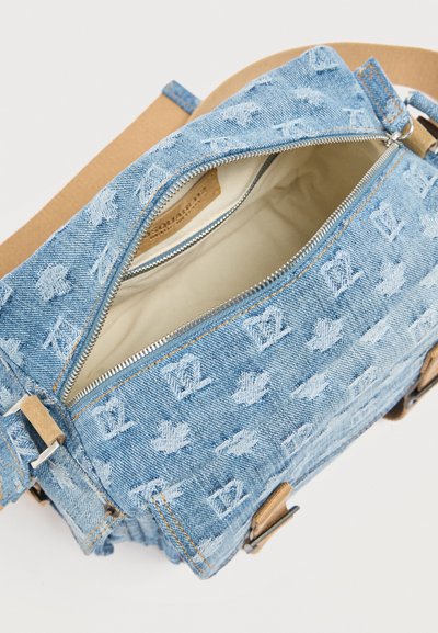 Τσάντα ώμου από τζιν με ανάγλυφα σχέδια, ασημένιο φερμουάρ, μπεζ εσωτερικό και ρυθμιζόμενο λουρί ταμπά κλιπσμένο σε μεταλλικούς κρίκους.