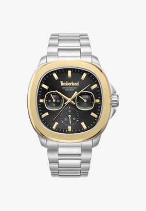 Kwadratowy zegarek z czarną tarczą, złotymi akcentami i srebrną bransoletą ze stali nierdzewnej. Cechy obejmują wyświetlacze daty i dnia, podświetlane oznaczenia godzin.