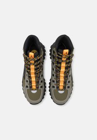 Hiking boots with a green and black upper, orange front lacing, textured sole, and patterned laces for enhanced grip and support.