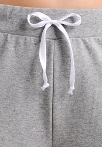 Szare bawełniane spodnie ze ściągaczem i białym troczkiem w talii, charakteryzujące się miękką fakturą i dwoma bocznymi kieszeniami.