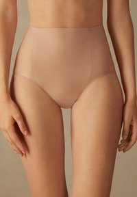 Höga trosor i nude med sömlös design, tillverkade av ett mjukt, elastiskt tyg. Har en ren finish och medelhög täckning för komfort och passform.
