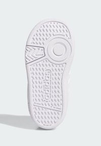 Bílá podrážka tenisky se strukturovaným gumovým povrchem, vrhající se do cik-cak vzoru, s kruhovým výřezem a značením "adidas" vylisovaným na boku.